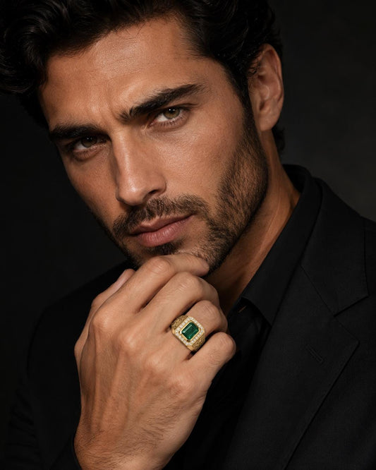 A man in a black suit and green ring is captured in a close-up portrait against a dark background.