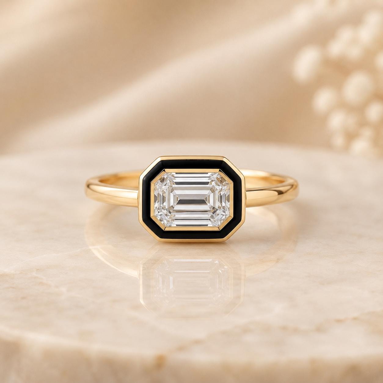 A gold ring with a large, clear gemstone set in a black-and-gold bezel.