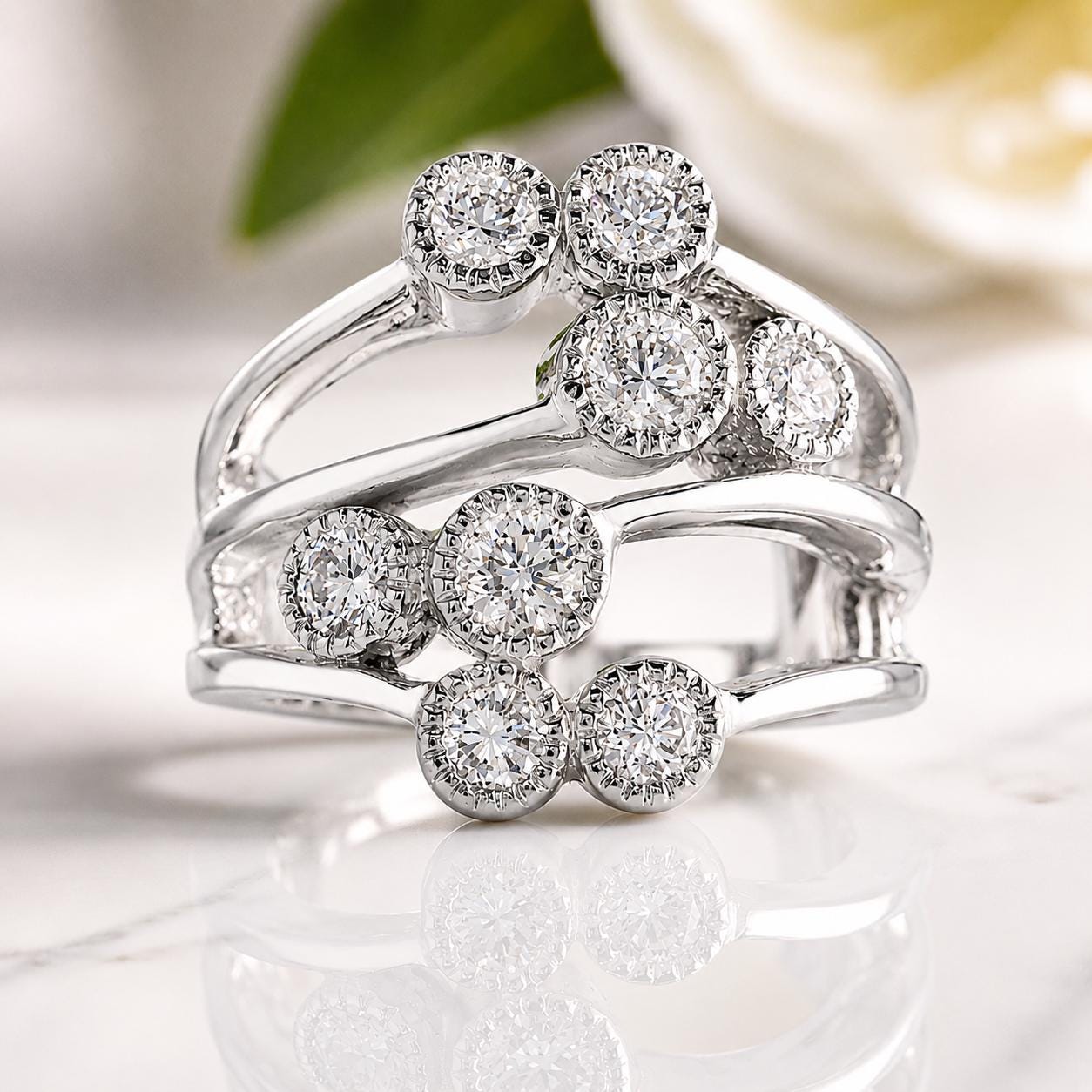 A close-up image of a silver ring with multiple diamond-encrusted stones set in a unique design.