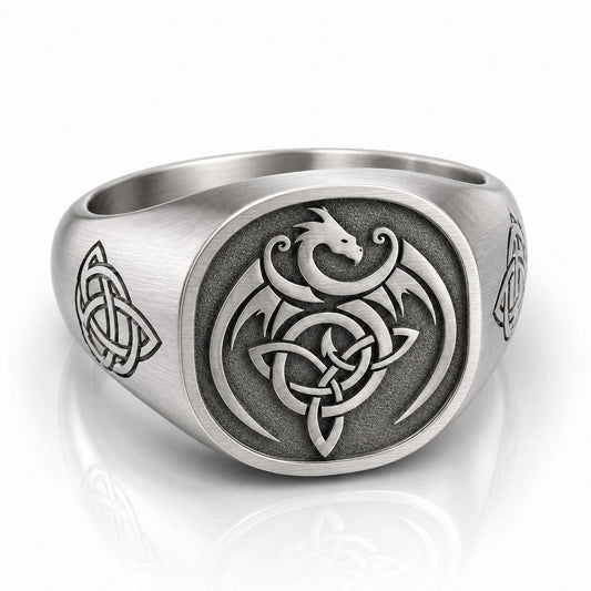 A silver ring with an intricate design featuring a dragon and a Celtic knot pattern.
