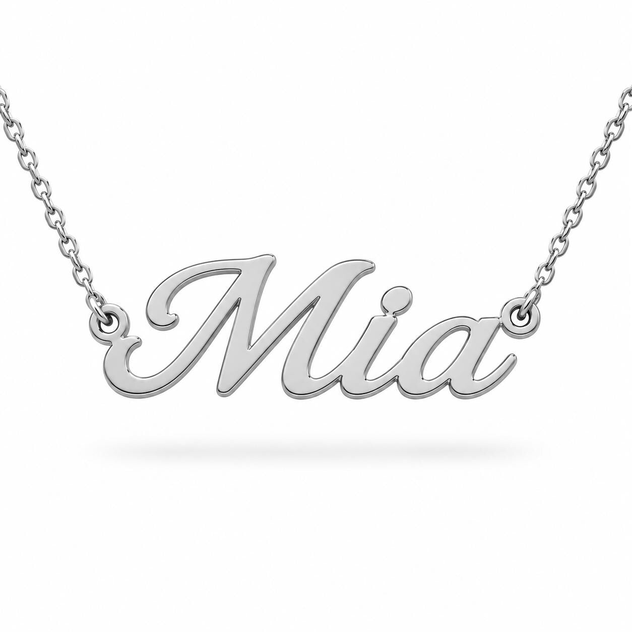 A silver necklace with the name "Mia" engraved on it.