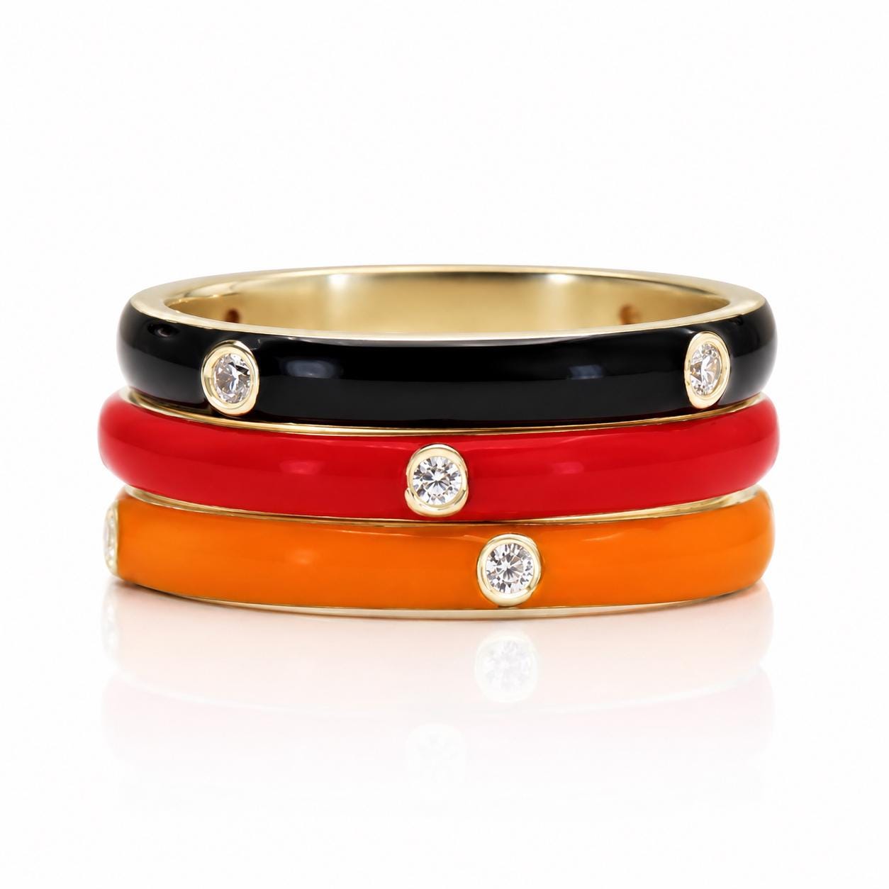 A stack of three colorful rings with gemstones on top.
