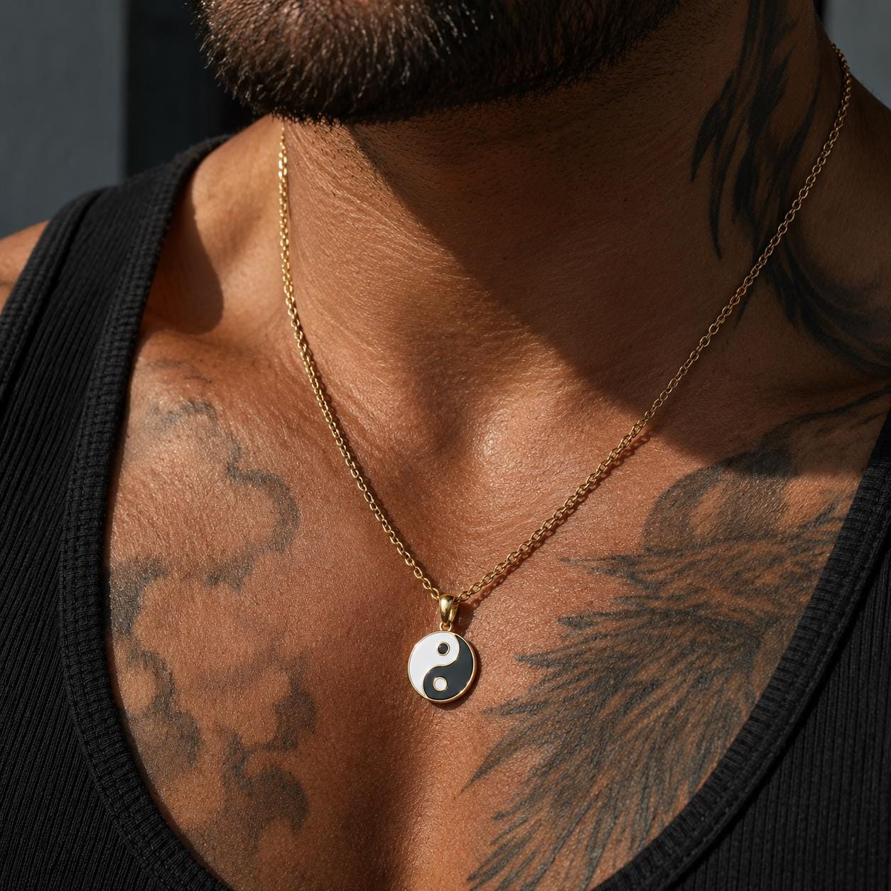 A close-up of a person's neck and chest area, featuring a gold chain necklace with a pendant.