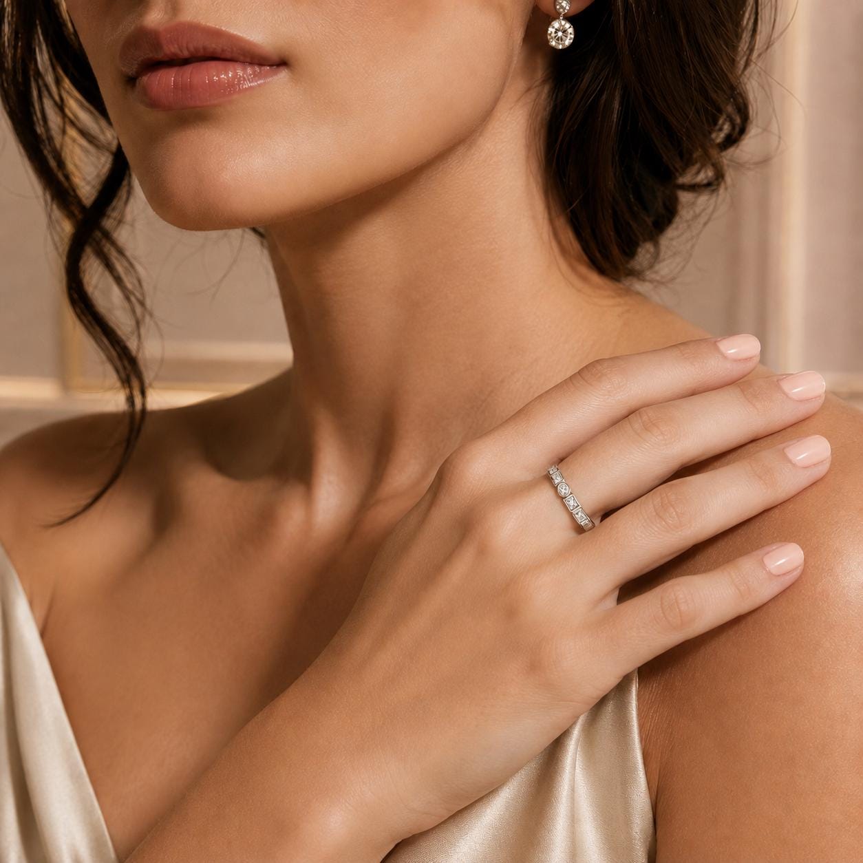 A close-up of a woman's hand wearing a diamond ring, with her hair styled in a bun.
