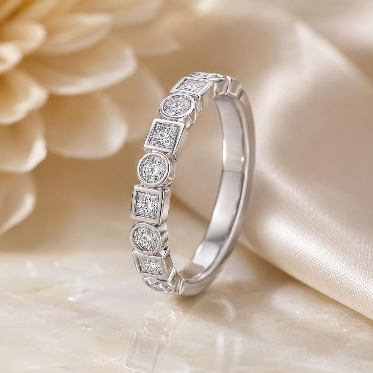 A silver ring with a row of small diamonds set in a beige fabric background.