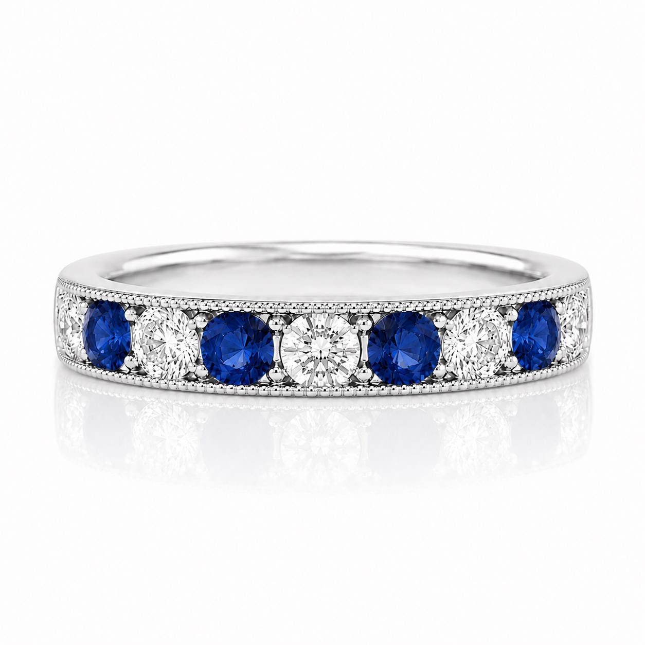 A silver ring with a row of blue sapphires and diamonds set in it.