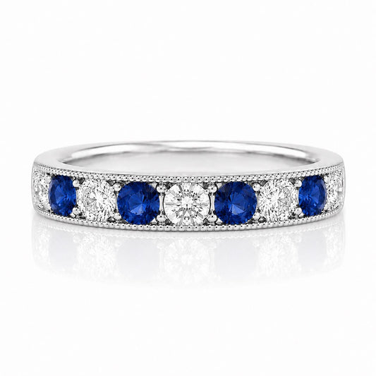 A silver ring with a row of blue sapphires and diamonds set in it.