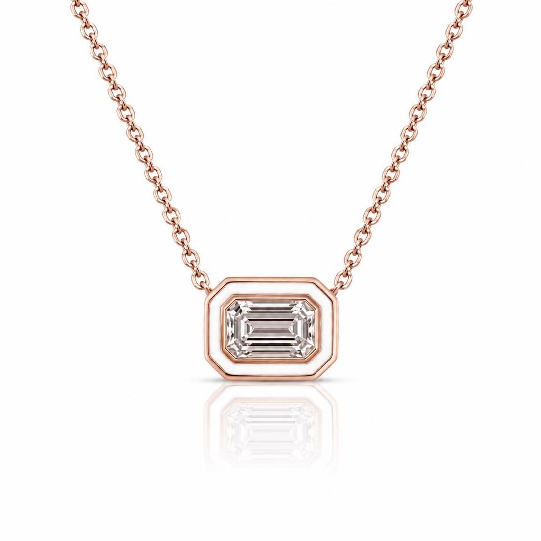 A delicate rose gold necklace with a large, clear gemstone pendant in the center.