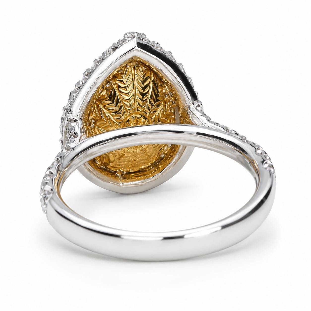 A silver ring with a large, intricately designed gold-colored stone set in the back.