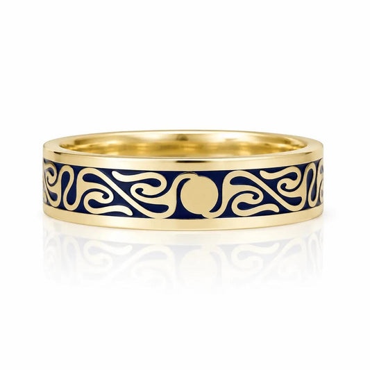 A gold ring with a blue and gold design featuring a central motif and swirling patterns.