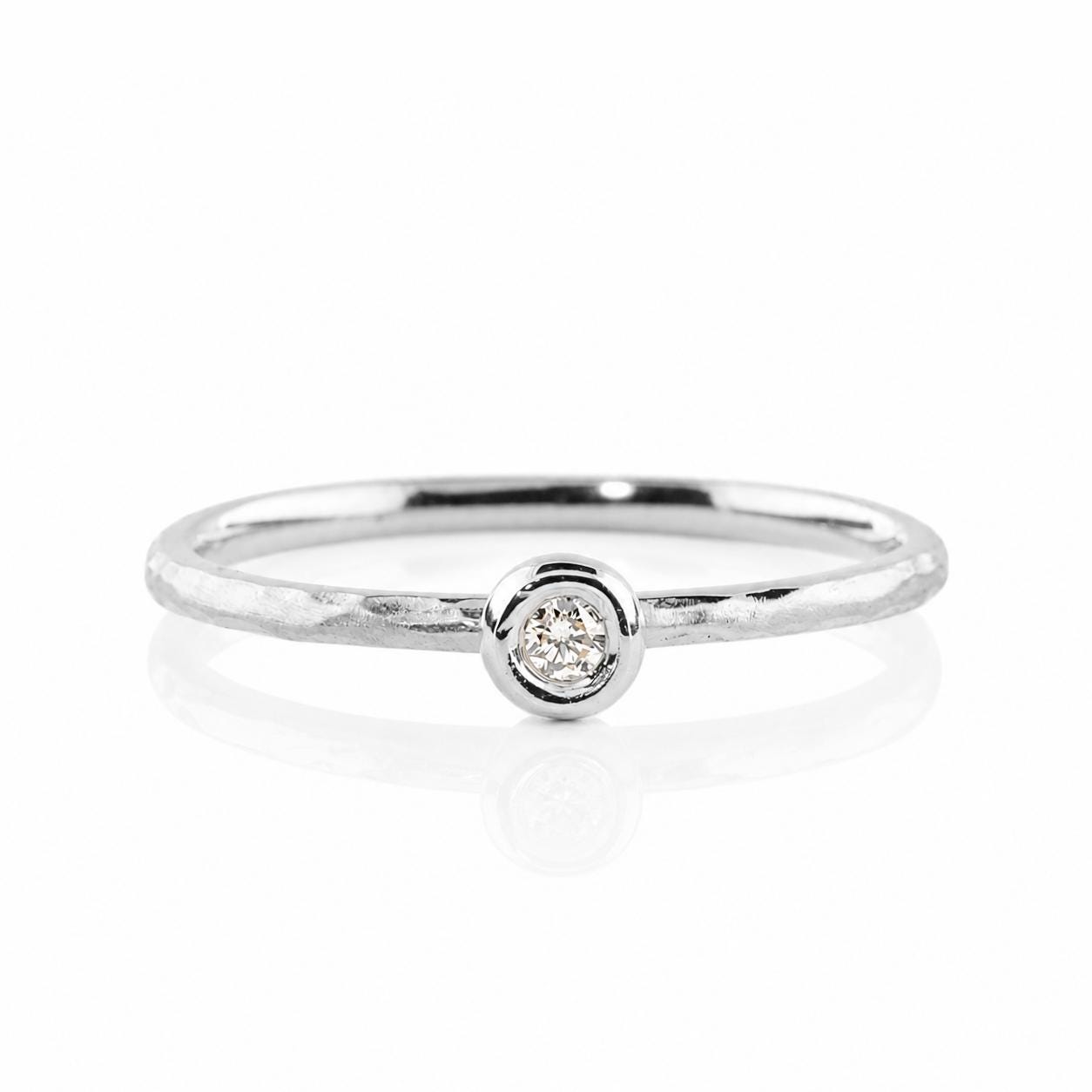 A simple silver ring with a small diamond set in the center.