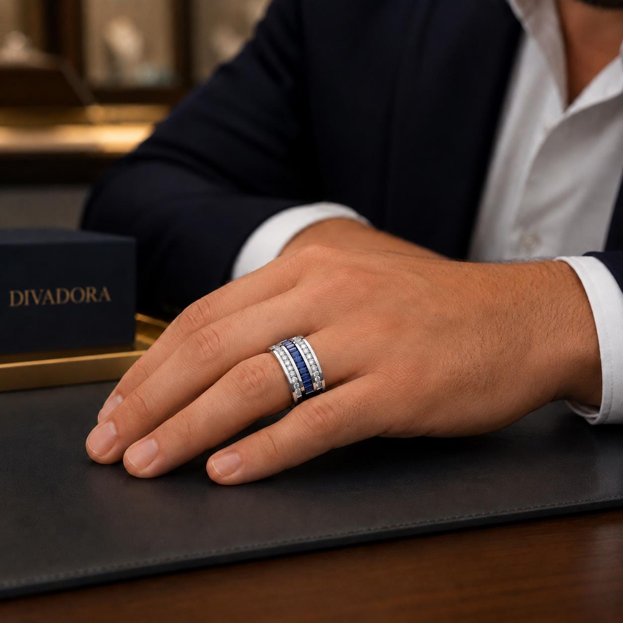 A close-up of a person's hand wearing a ring with multiple bands, resting on a desk.