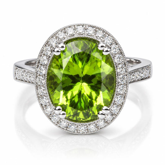 A stunning ring featuring a large oval-shaped green gemstone surrounded by a halo of smaller diamonds set in a silver band.