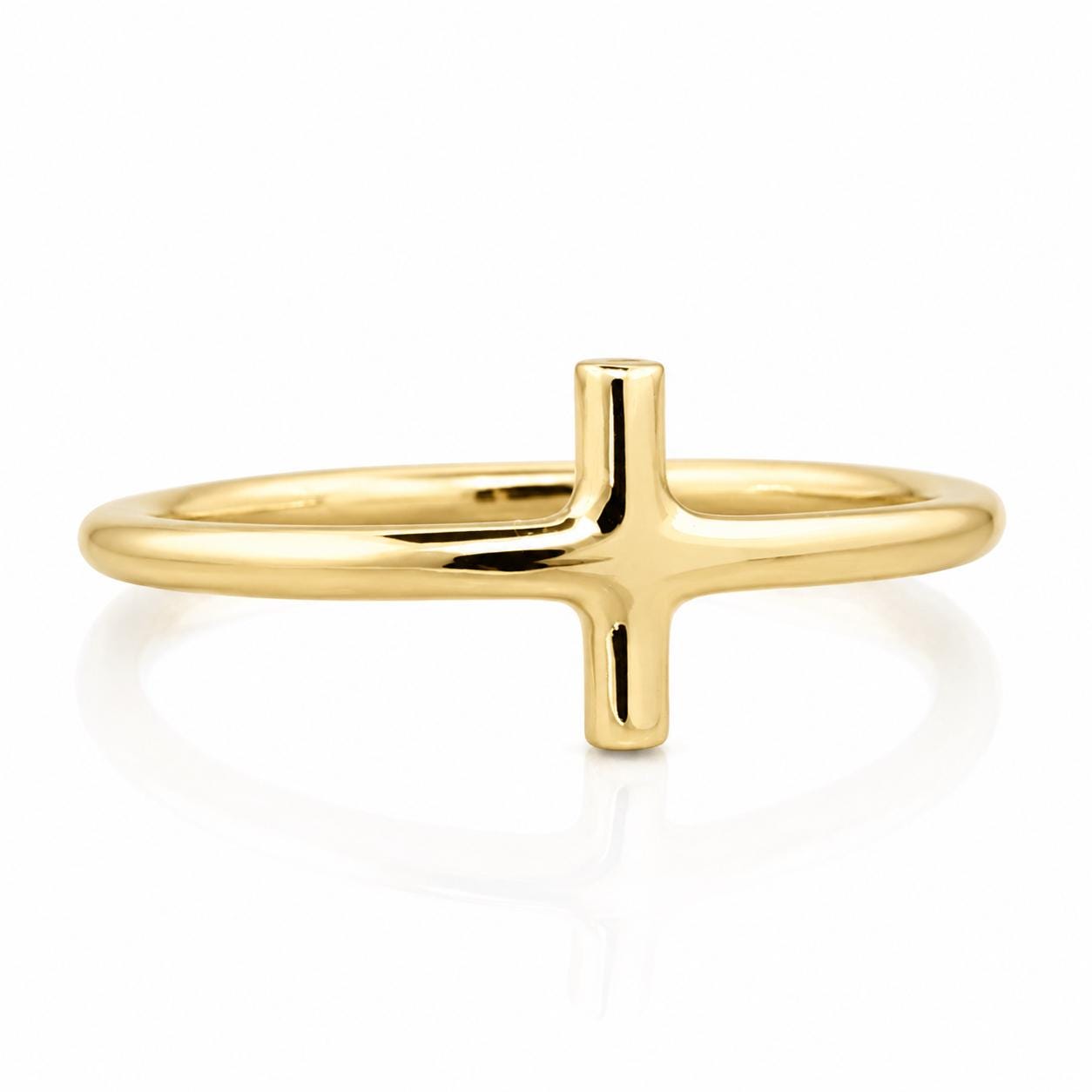 A simple gold ring with a large cross-shaped gemstone.