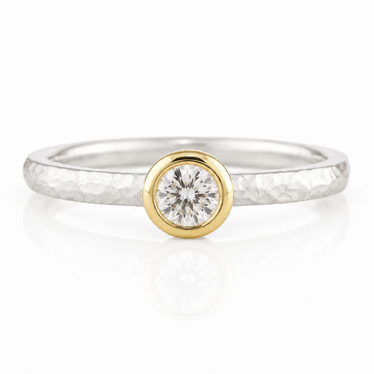 A silver ring with a large, round diamond set in the center.