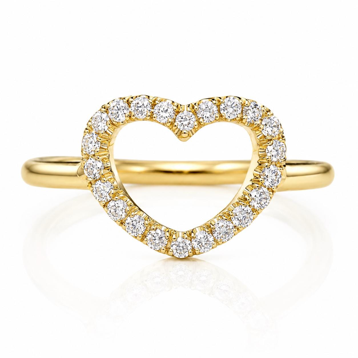 A gold ring with a heart-shaped cutout in the center, surrounded by a row of small diamonds.