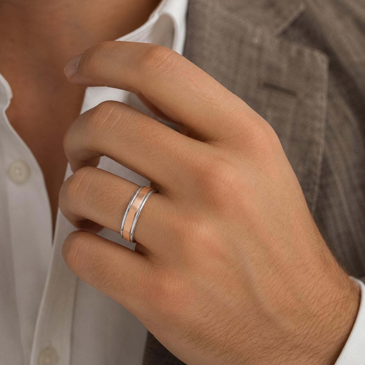 A close-up of a person's hand wearing a ring on the ring finger.