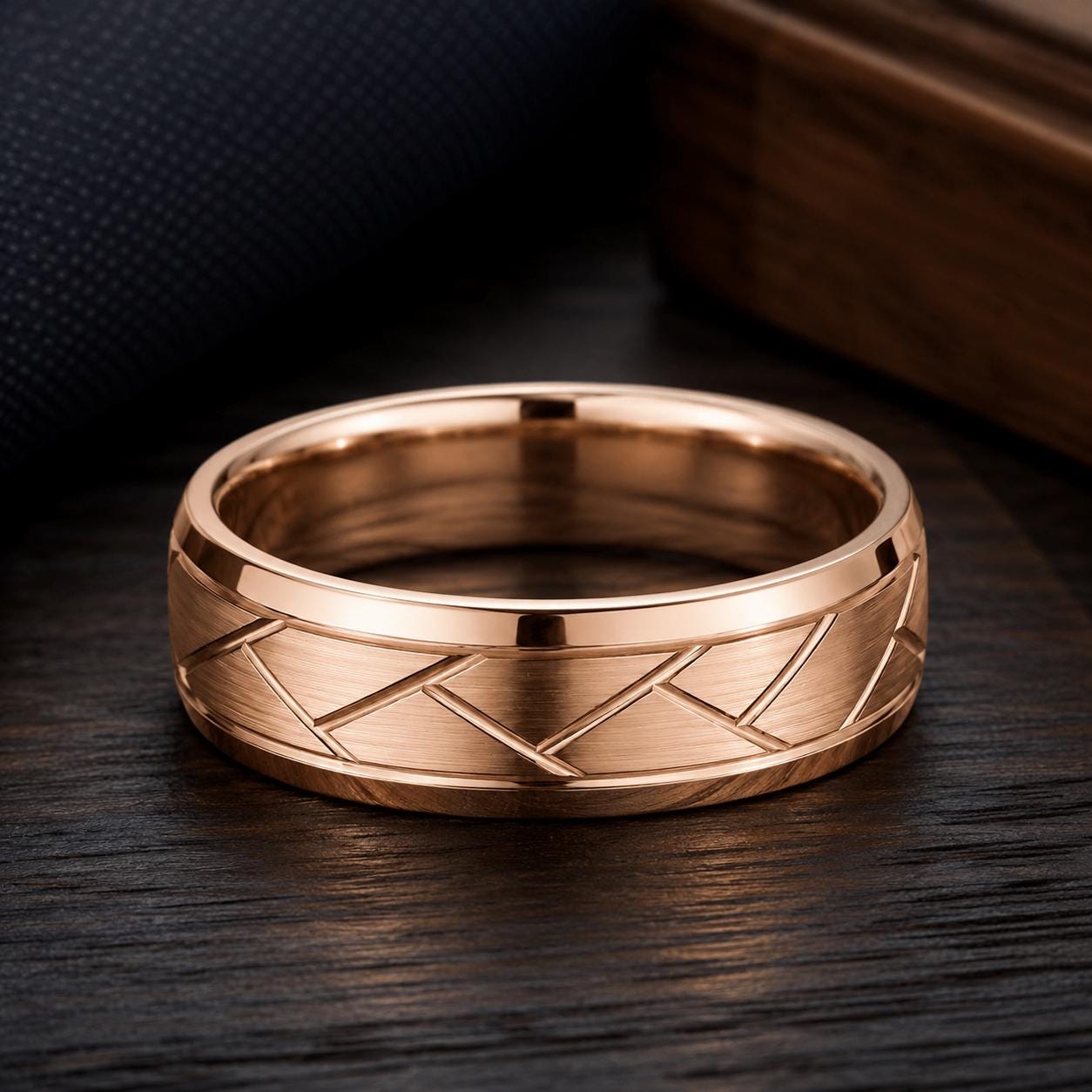A gold-colored ring with a geometric pattern sits on a dark wooden surface.