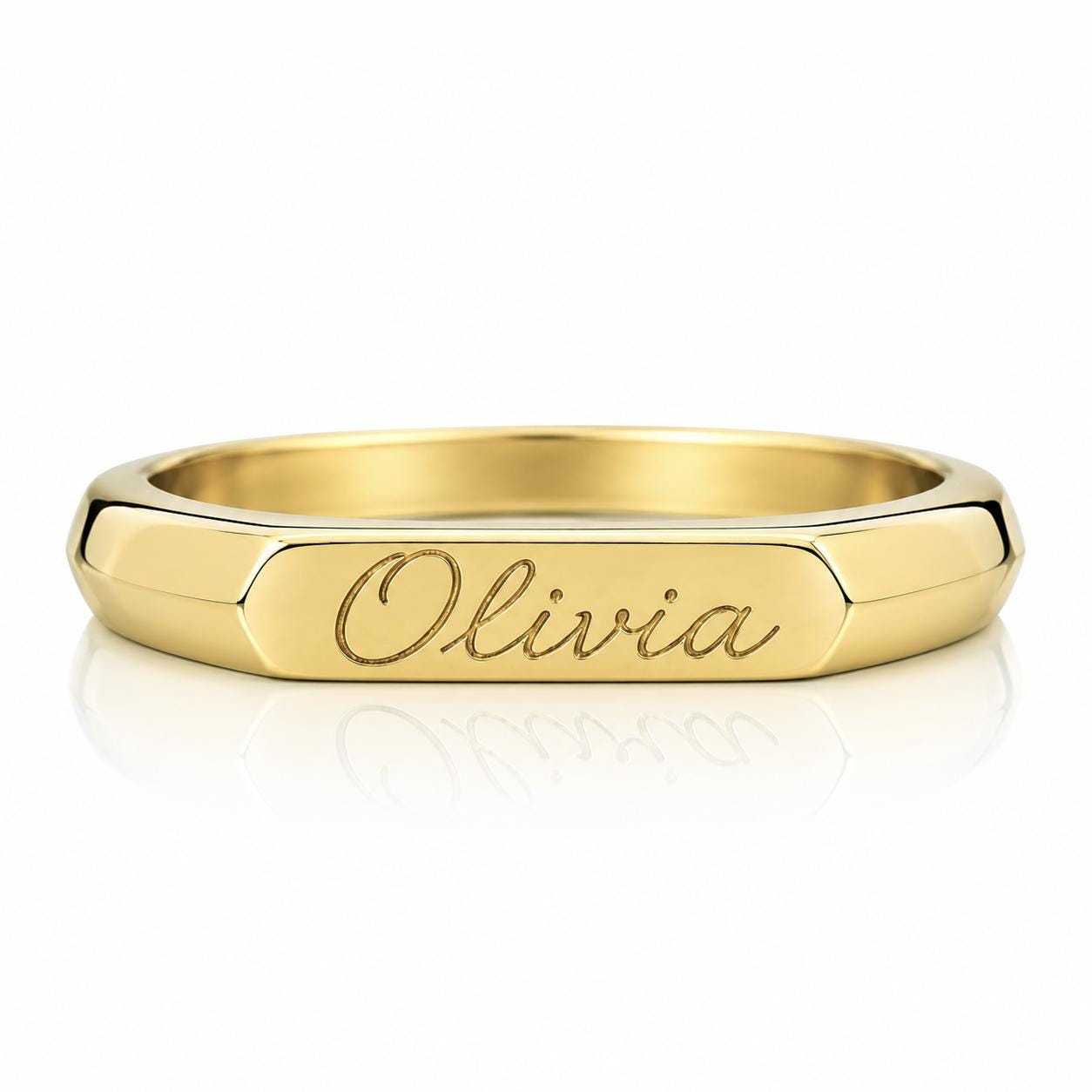A gold ring with the name "Olivia" engraved on it.