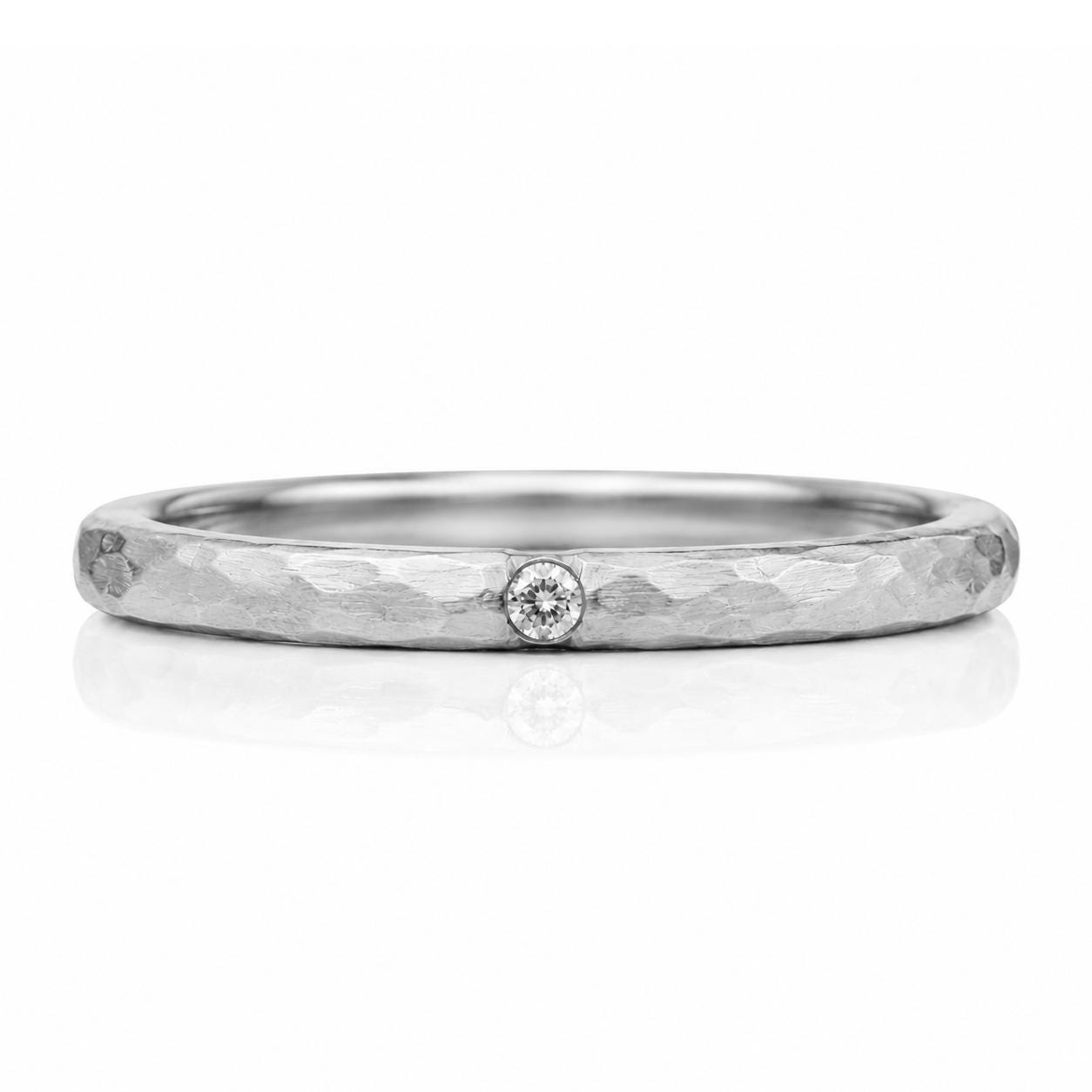 A silver-colored ring with a small diamond set in the center.