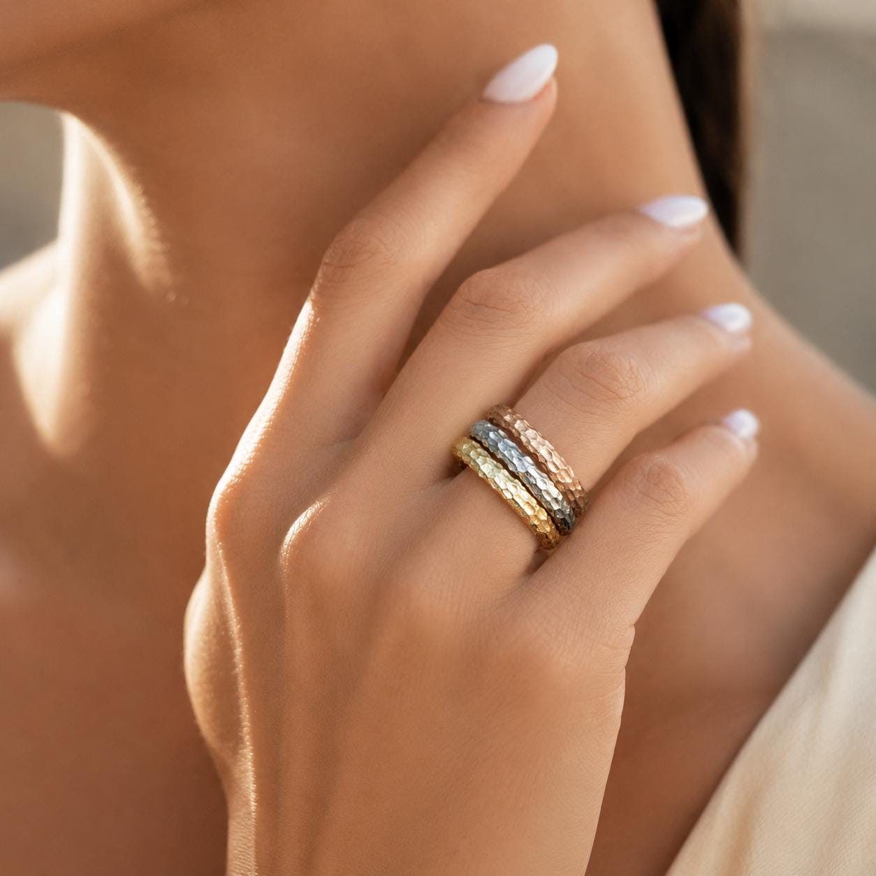 A close-up of a person's hand wearing a ring with multiple bands, showcasing the intricate design and craftsmanship of the jewelry.