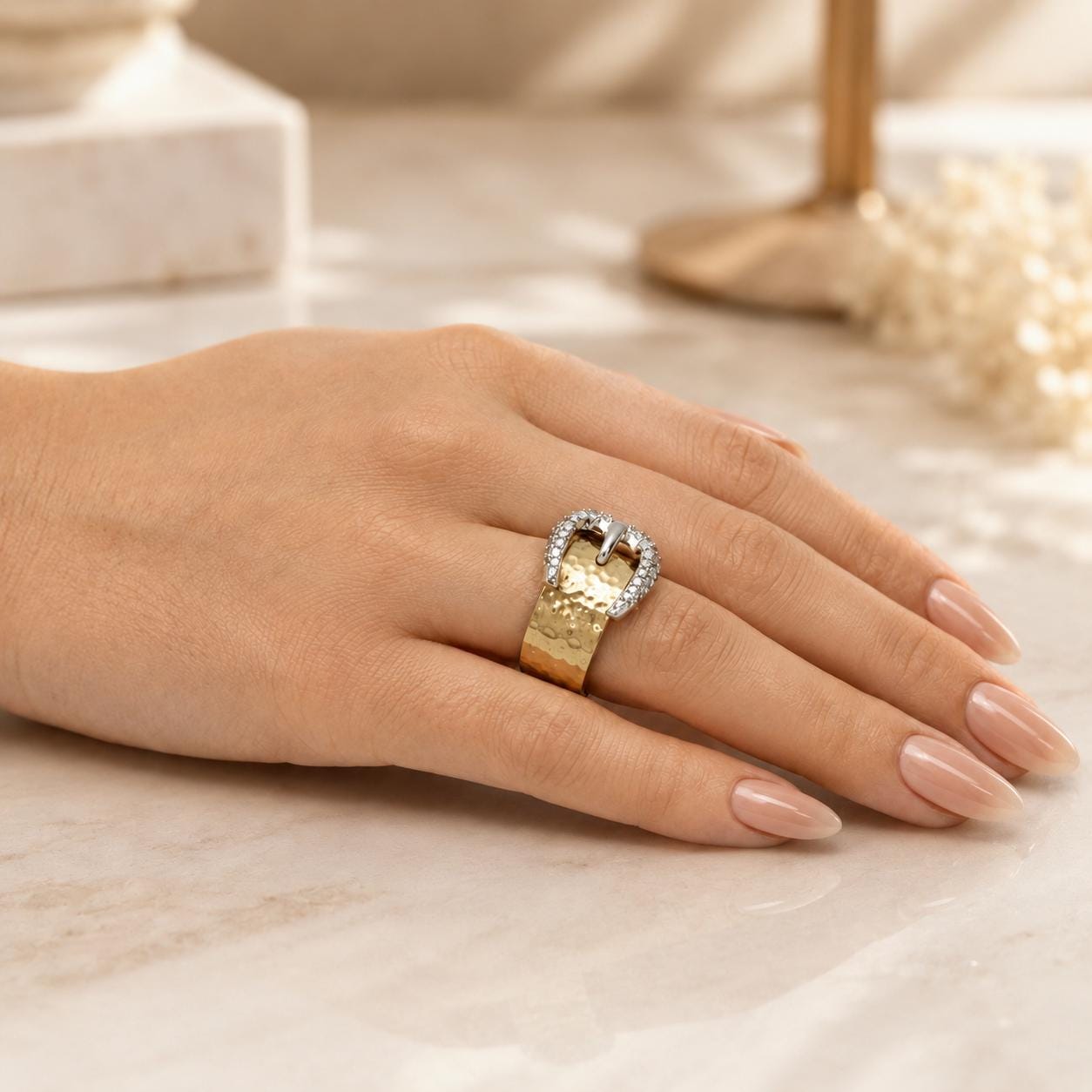 A close-up of a hand wearing a gold ring with a large diamond in the center.