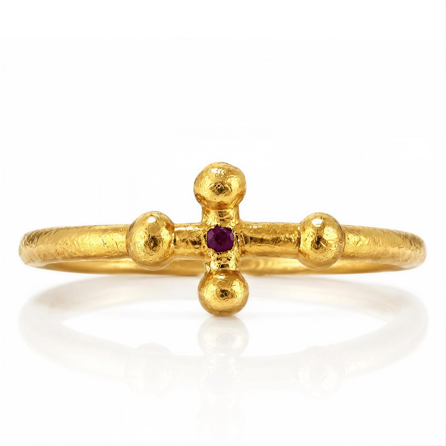 A gold ring with a cross-shaped gemstone in the center.