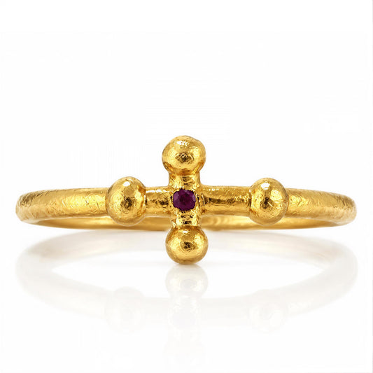 A gold ring with a cross-shaped gemstone in the center.