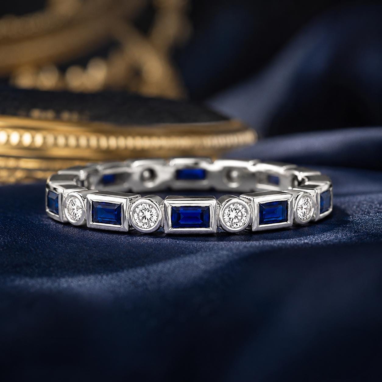 A silver and blue diamond-encrusted bracelet is displayed on a blue fabric surface.