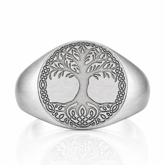 A silver ring with a tree design in the center, surrounded by intricate Celtic knot patterns.