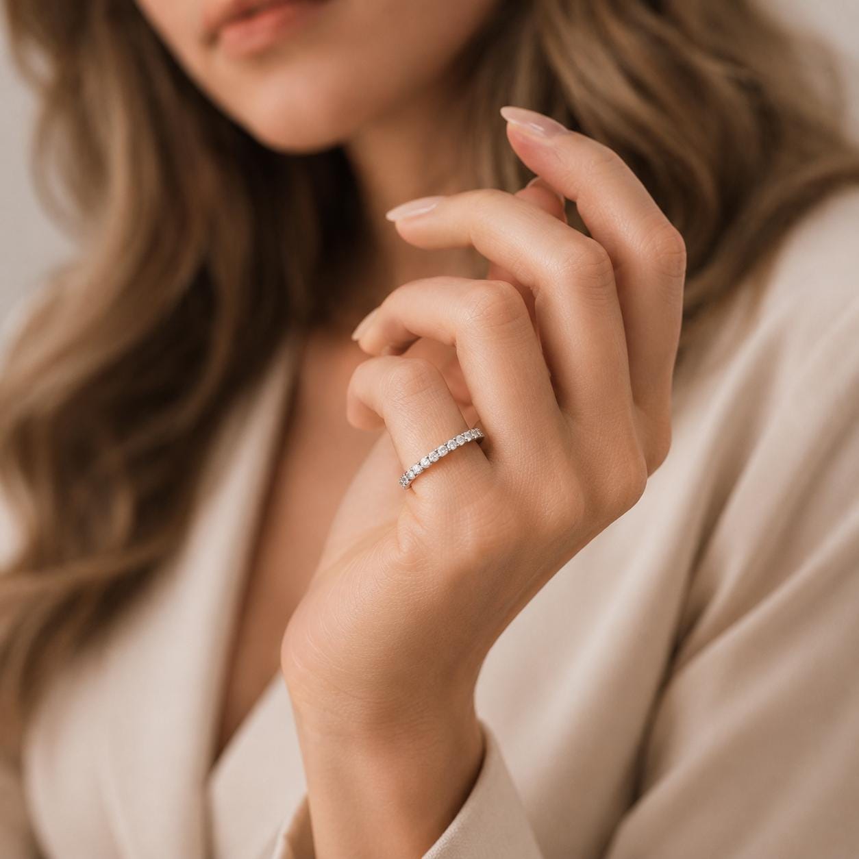 A close-up of a woman's hand wearing a diamond ring, with her fingers gently curled around the ring.