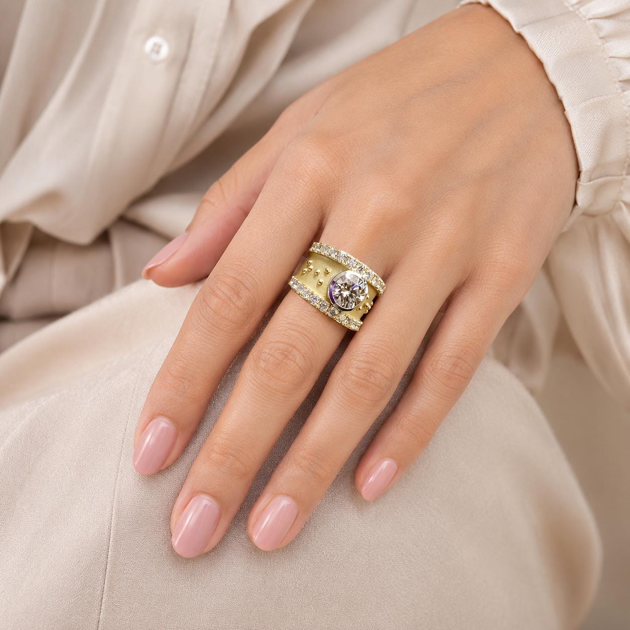 A close-up of a person's hand wearing a gold ring with a large gemstone.