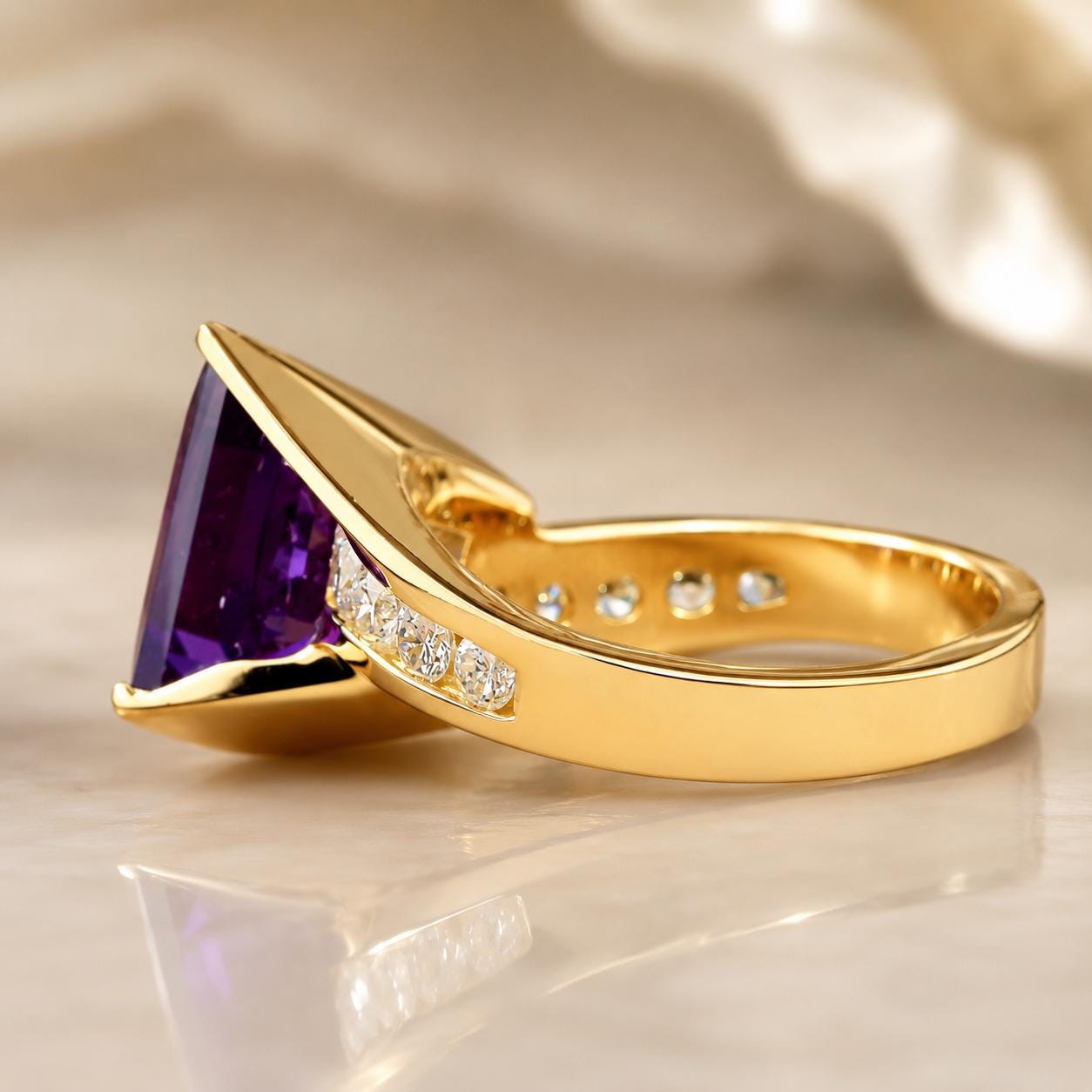A gold ring with a large purple gemstone, likely an amethyst, set in the center.
