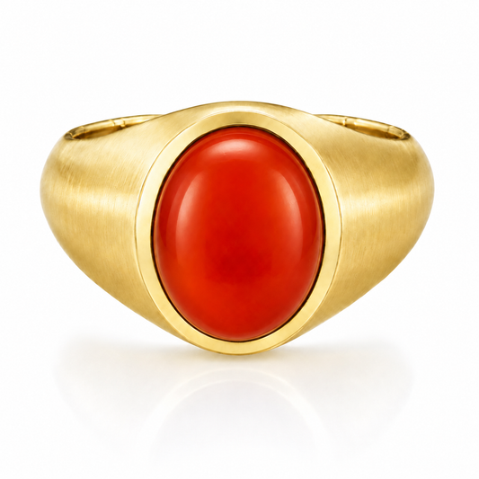 A gold ring with a large, bright red gemstone in the center.