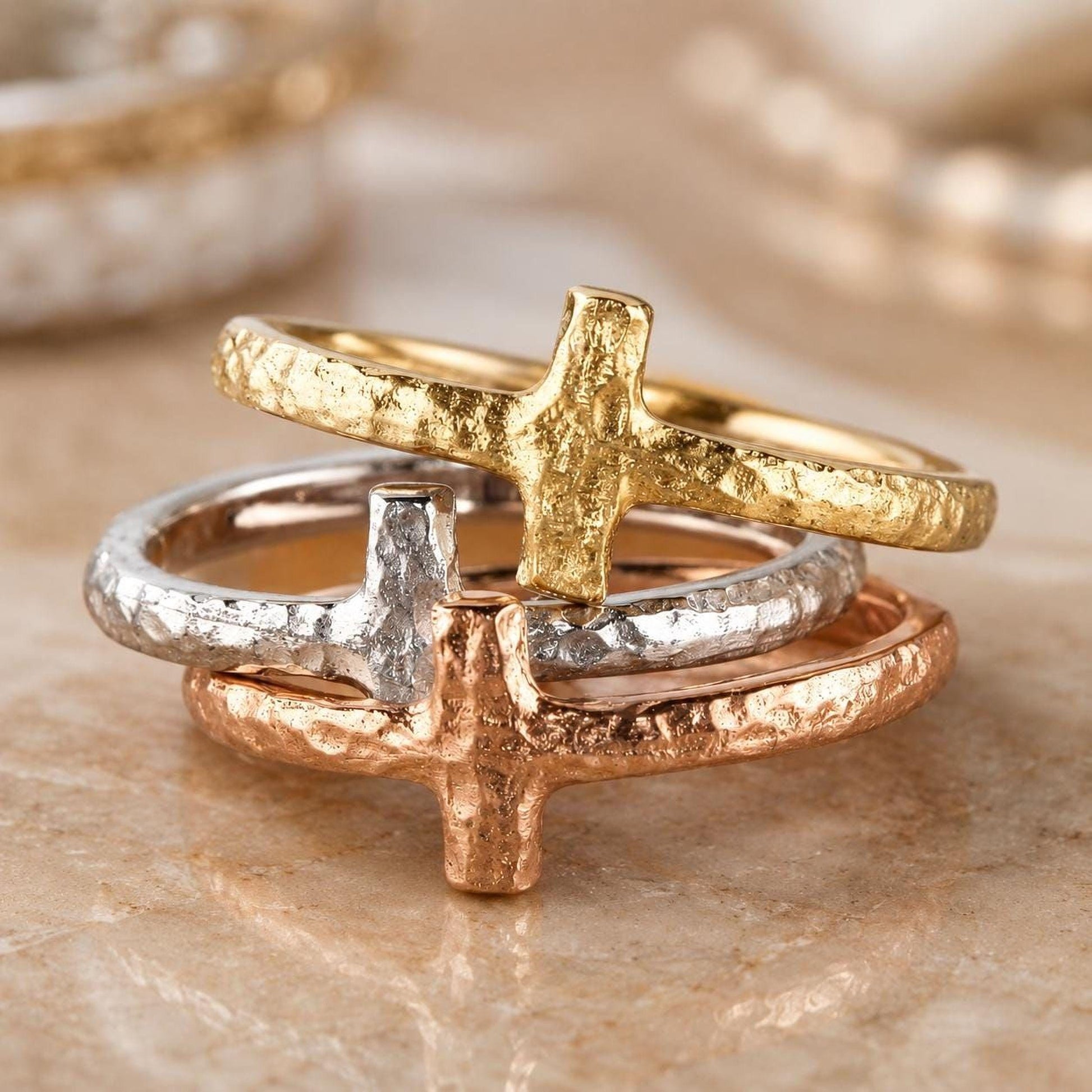 A close-up image of three rings with a cross design, showcasing the intricate details and craftsmanship of the jewelry.