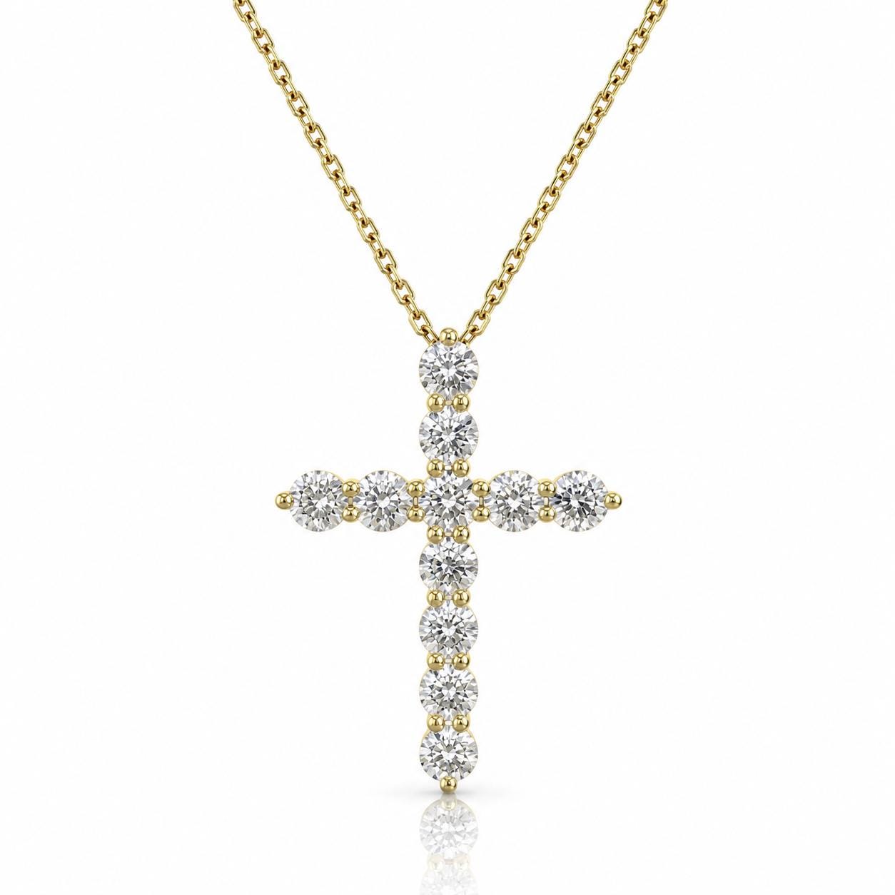 A gold-colored necklace with a large, intricately designed diamond cross pendant.