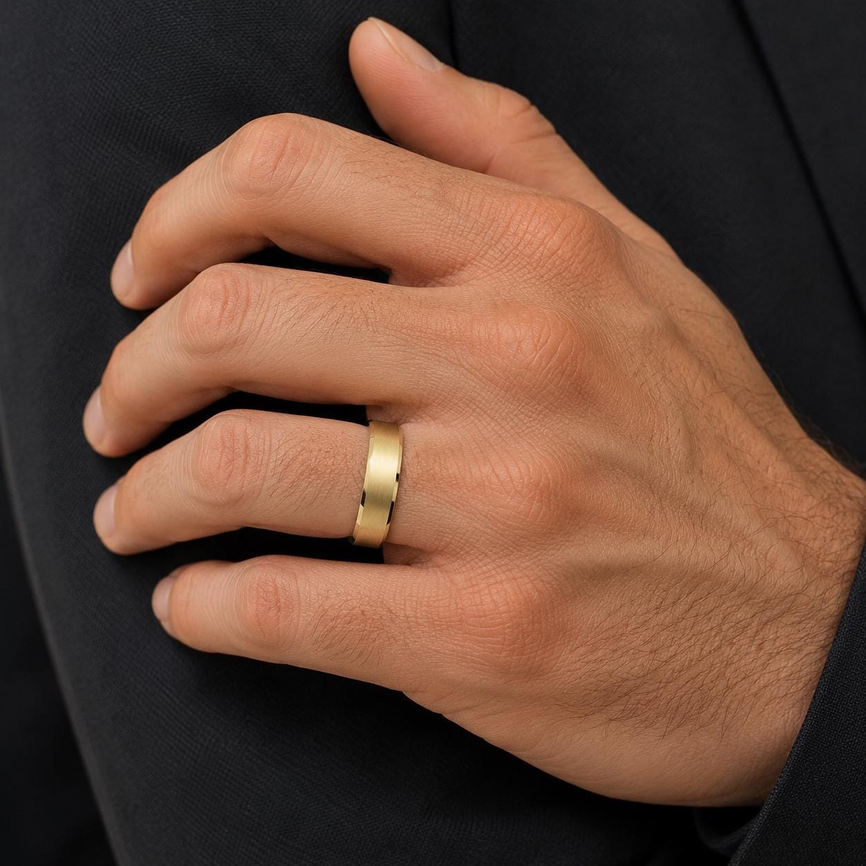 A close-up of a person's hand wearing a gold wedding ring.