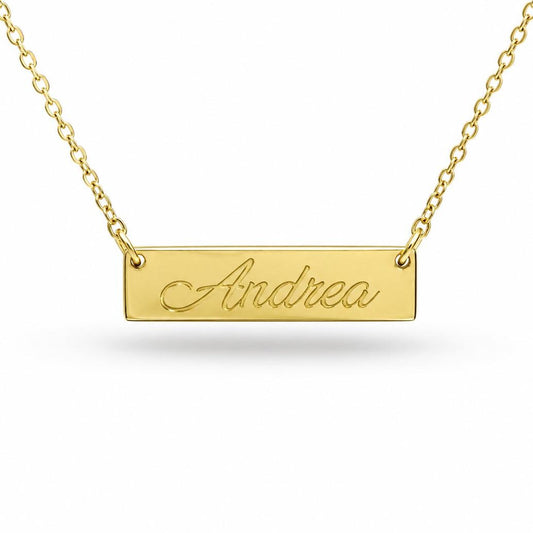 A gold-colored necklace with a rectangular pendant engraved with the name "Andrea".