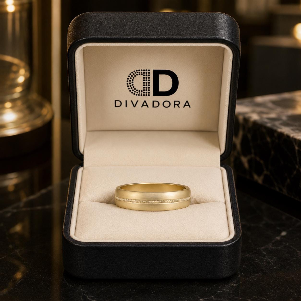 A gold wedding band is displayed in a black jewelry box with the Divadora logo on the inside.