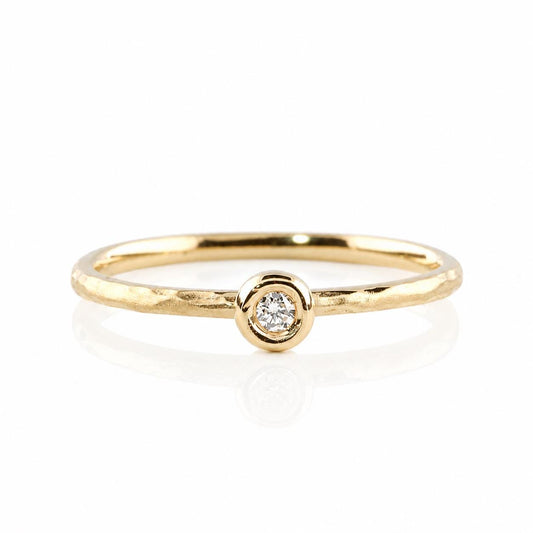 A simple gold ring with a small diamond set in the center.