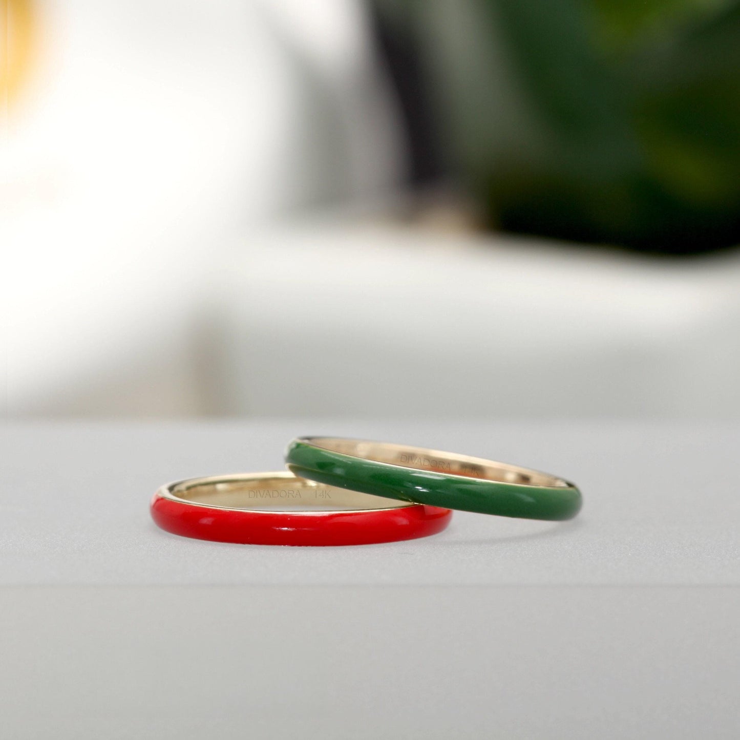 Two rings, one red and one green, are placed on a white surface.