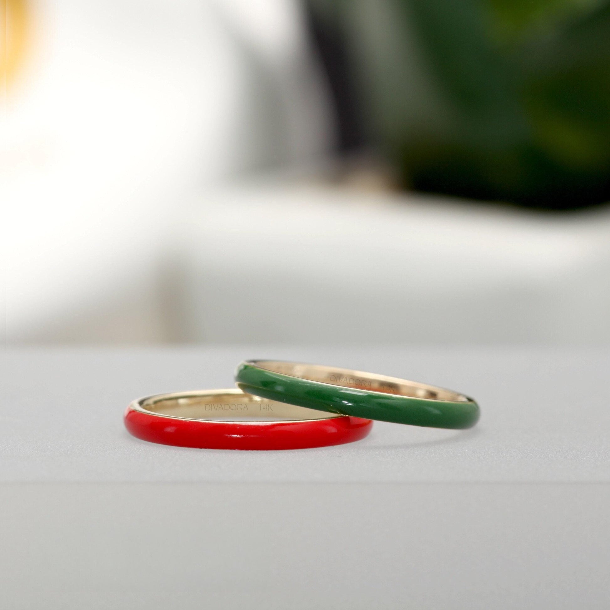 Two rings, one red and one green, are placed on a white surface.