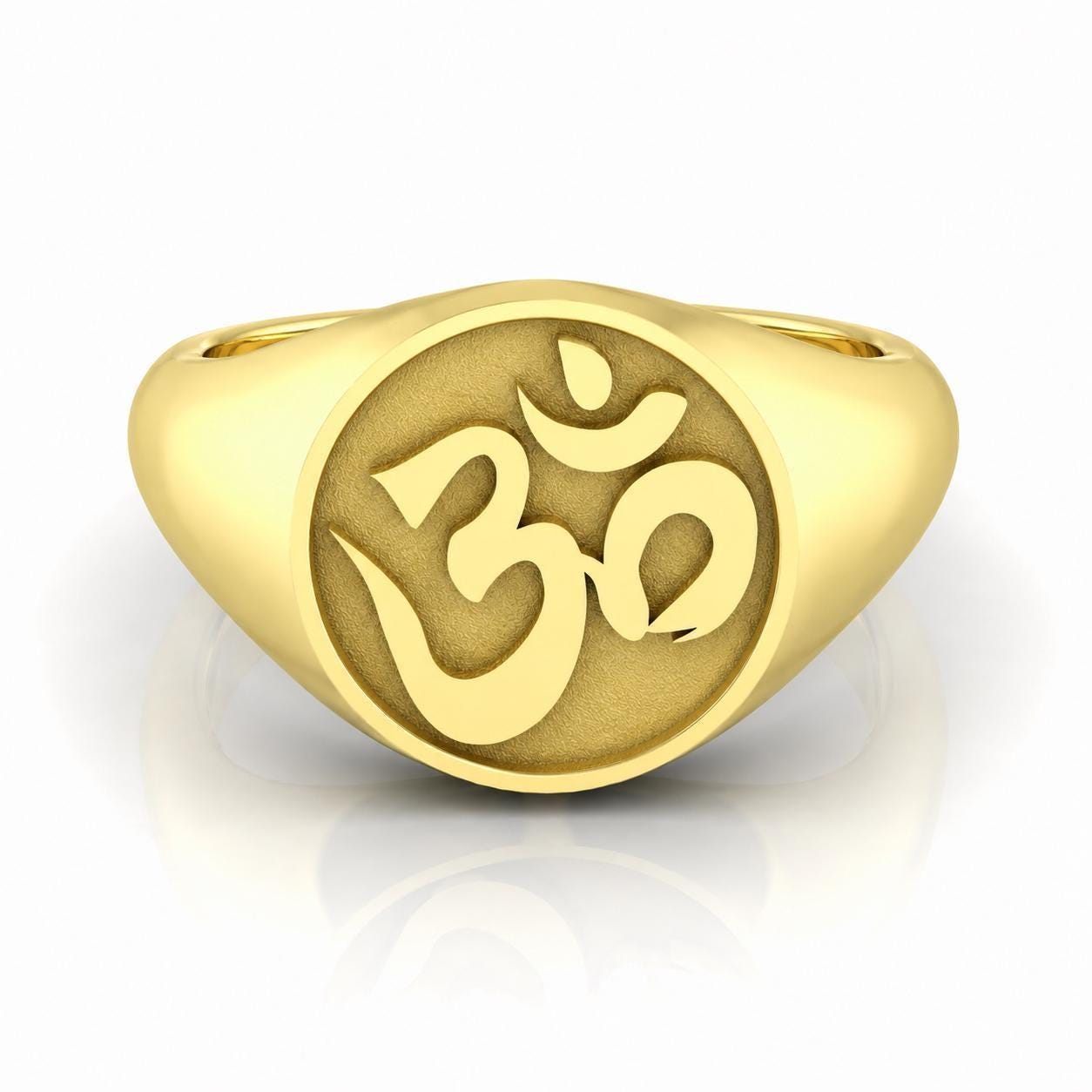 A gold ring with the Om symbol engraved on it.