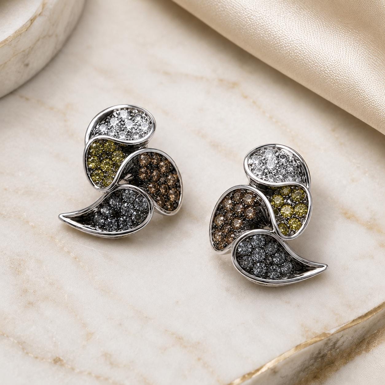 A pair of elegant earrings with a combination of colorful gemstones, including diamonds and pearls, set in a silver-toned metal design.