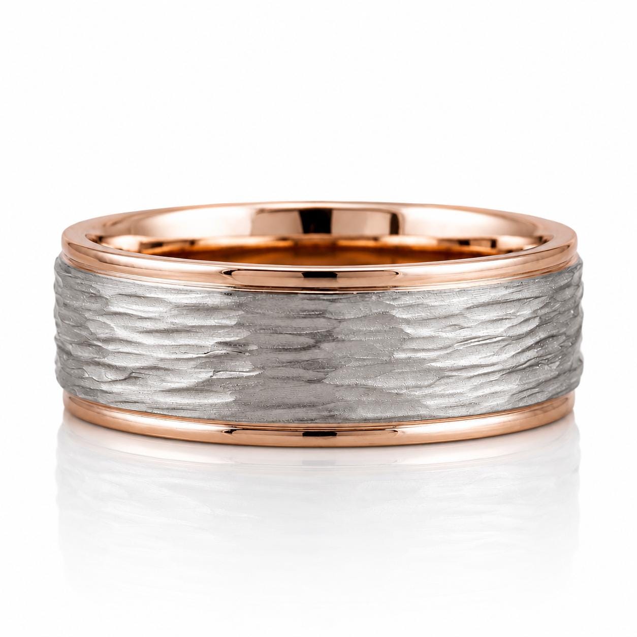 A ring with a textured silver band and a thin gold band, set against a white background.