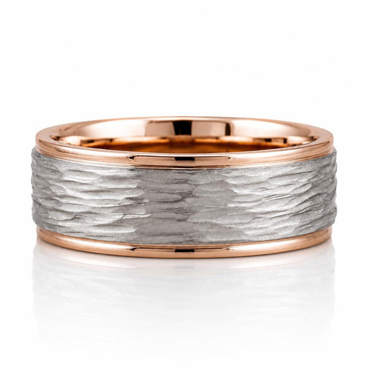 A ring with a textured silver band and a thin gold band, set against a white background.