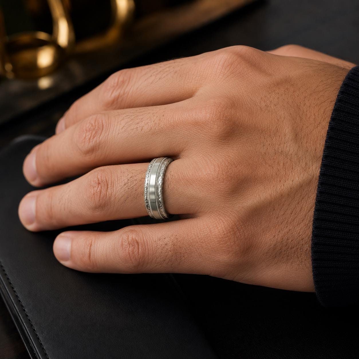 A close-up of a person's hand wearing a silver ring on the ring finger.