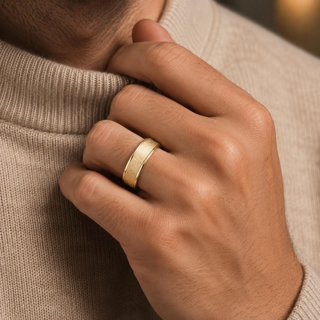 A close-up of a person's hand wearing a gold ring on the ring finger.