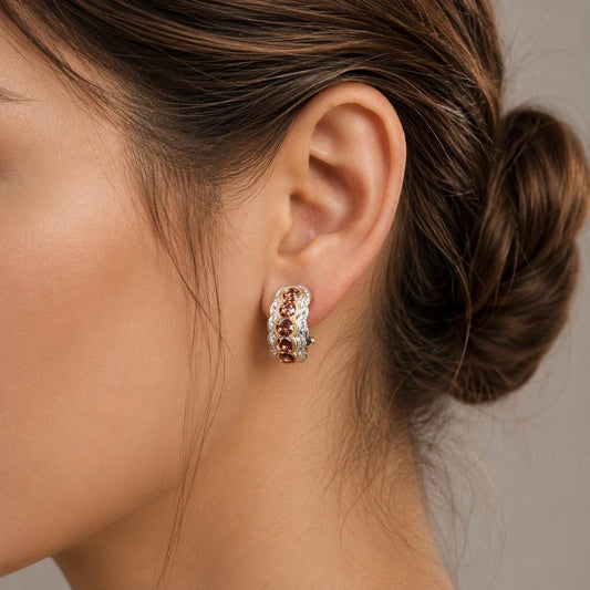 A close-up of a woman's ear wearing a pair of earrings with colorful gemstones.