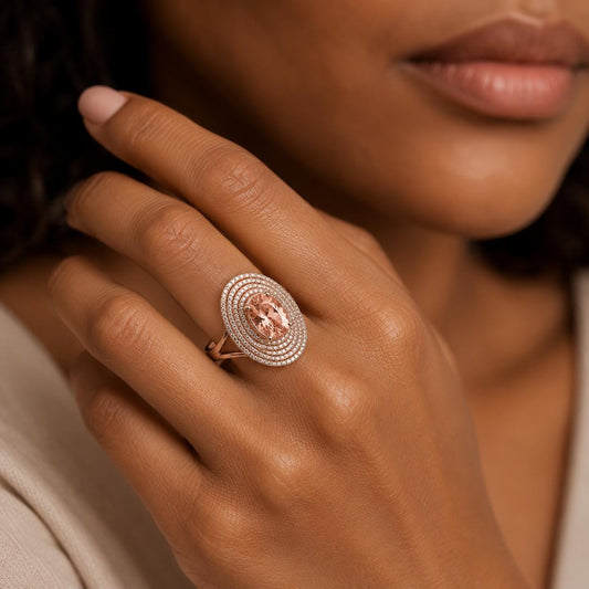A close-up of a woman's hand wearing a ring with a large oval-shaped gemstone.